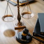 A striking image featuring a brass justice scale and gavel on a wooden desk, symbolizing law and justice.